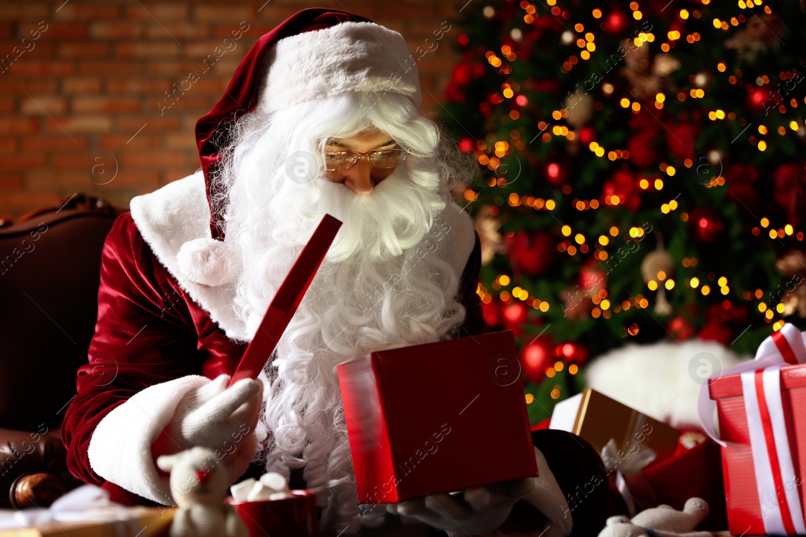 Photo of Santa Claus with gifts near Christmas tree