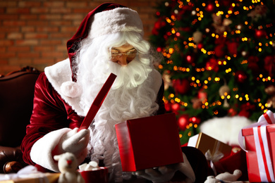 Santa Claus with gifts near Christmas tree