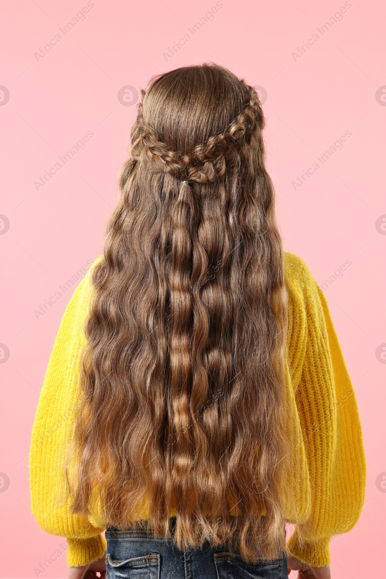 Photo of Little girl with braided hair on pink background, back view