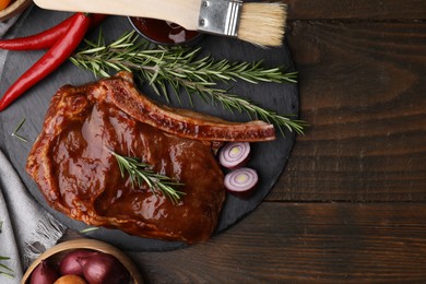 Photo of Tasty meat, rosemary, marinade and vegetables on wooden table, flat lay. Space for text