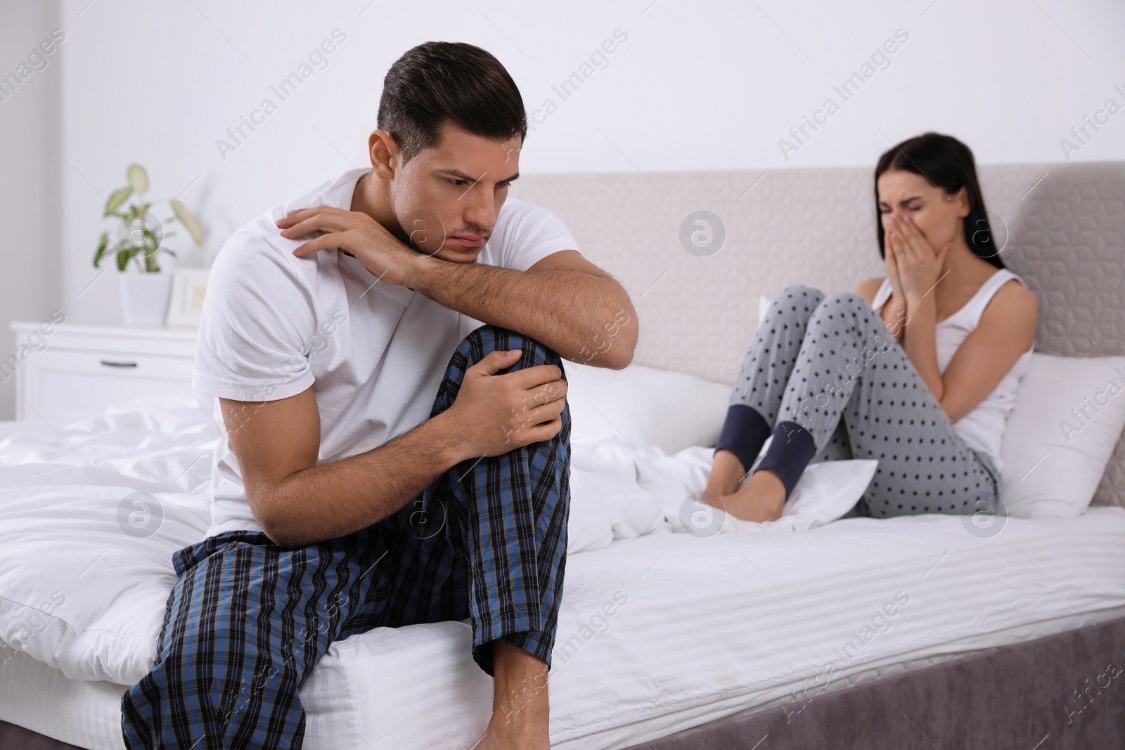 Photo of Unhappy couple with relationship problems after quarrel in bedroom