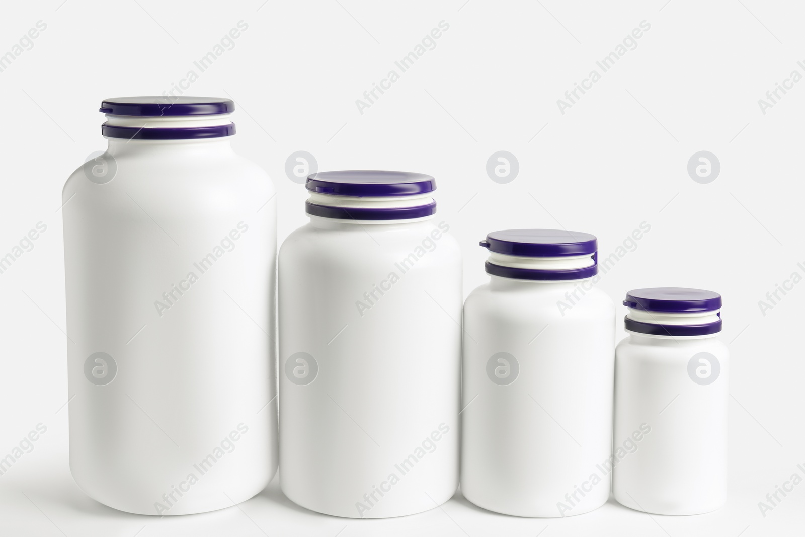 Photo of Row of different plastic medicine bottles on white background. Medicament