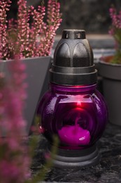 Photo of Grave lantern on grey granite surface at cemetery