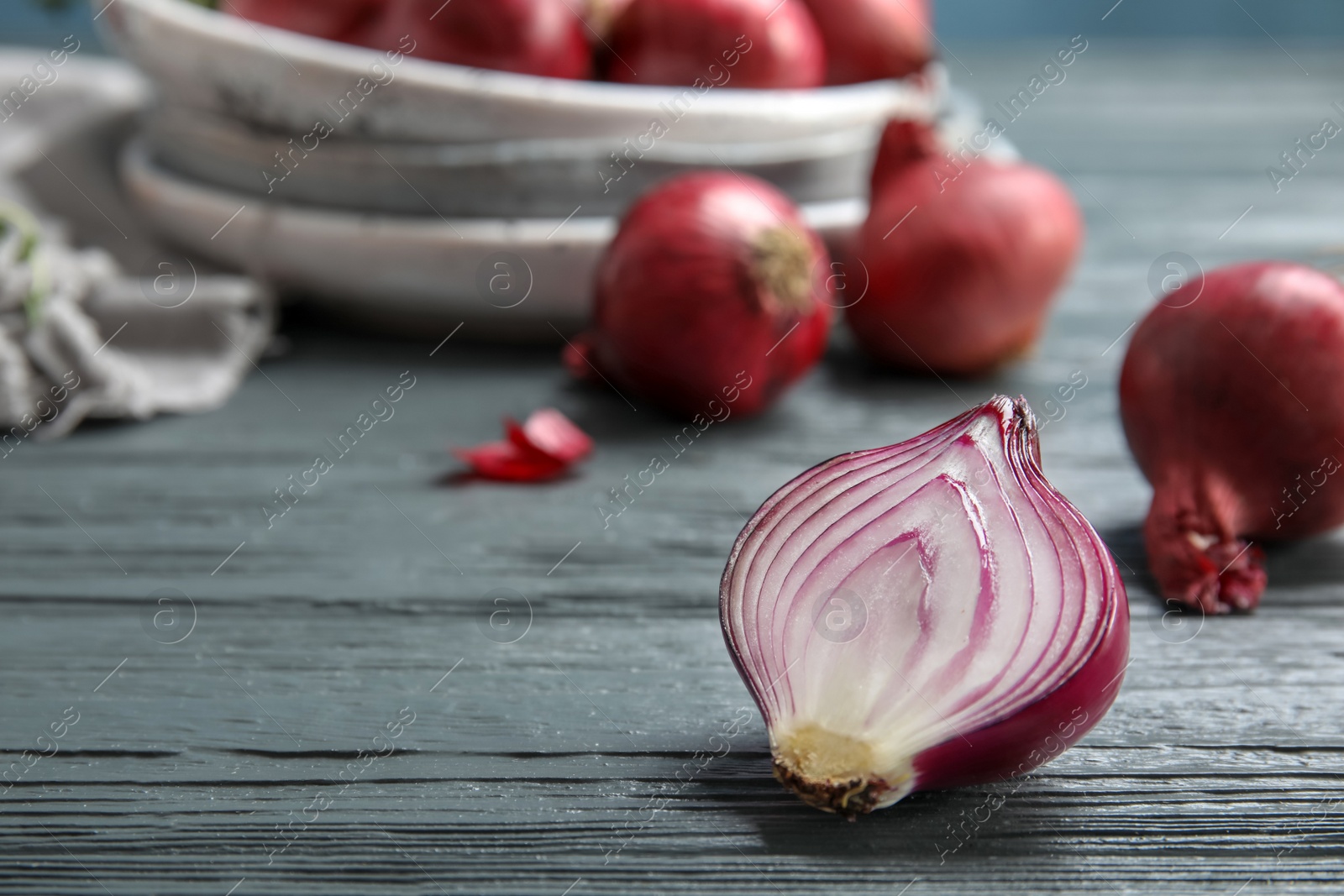 Photo of Half of red ripe onion on wooden table