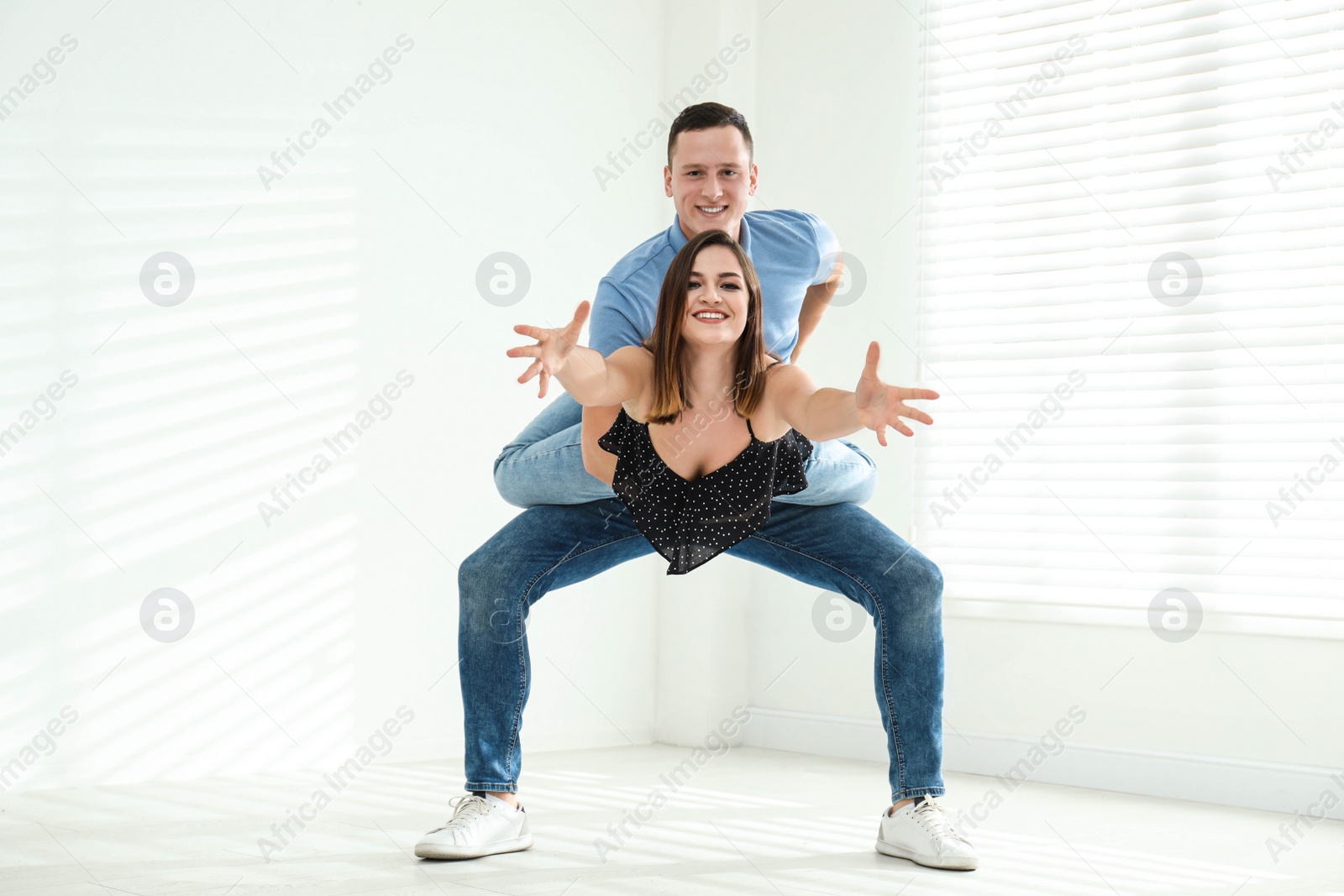 Photo of Happy young couple dancing in empty studio