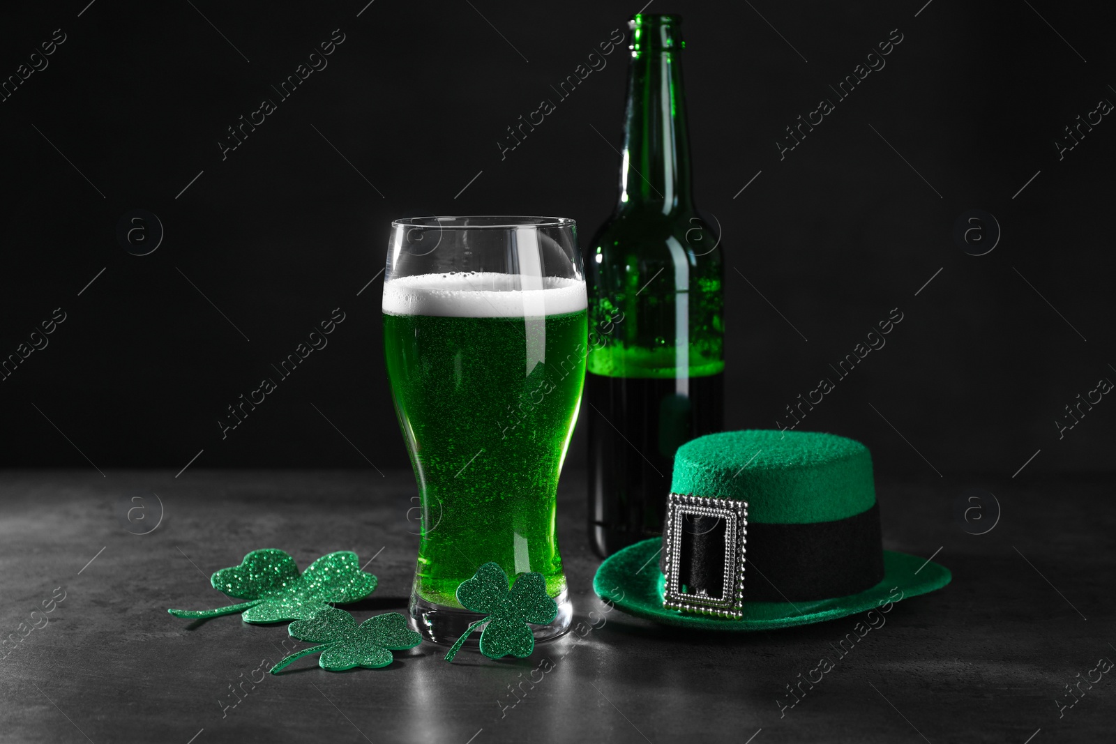 Photo of St. Patrick's day celebration. Green beer, leprechaun hat and decorative clover leaves on grey table