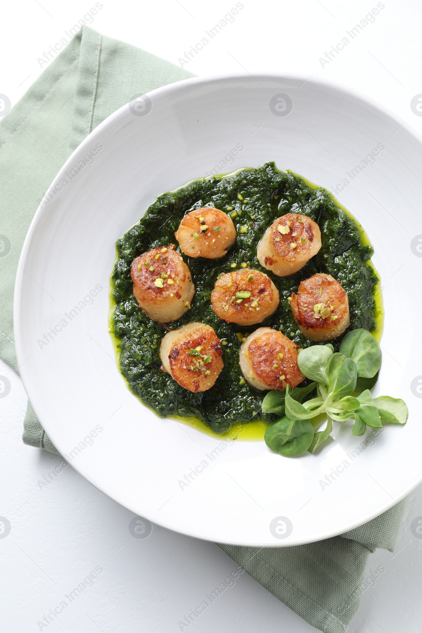 Photo of Delicious fried scallops with tasty sauce and corn salad in bowl on white table, top view