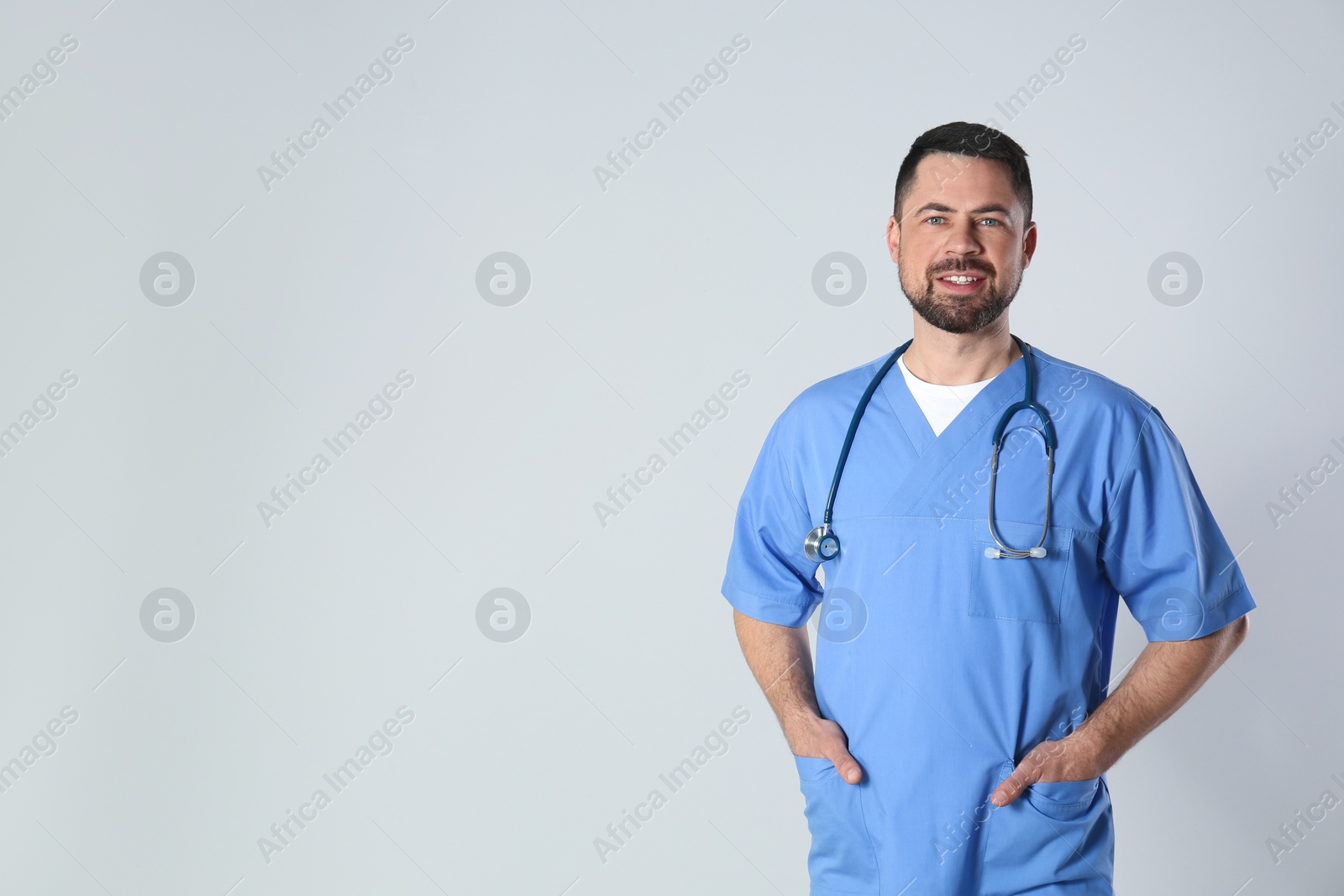 Photo of Portrait of mature doctor against light background