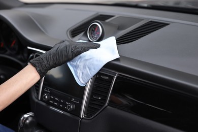 Woman wiping her modern car with rag, closeup