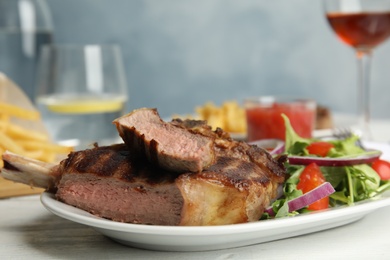 Image of Grilled steak with fresh salad on white table, closeup