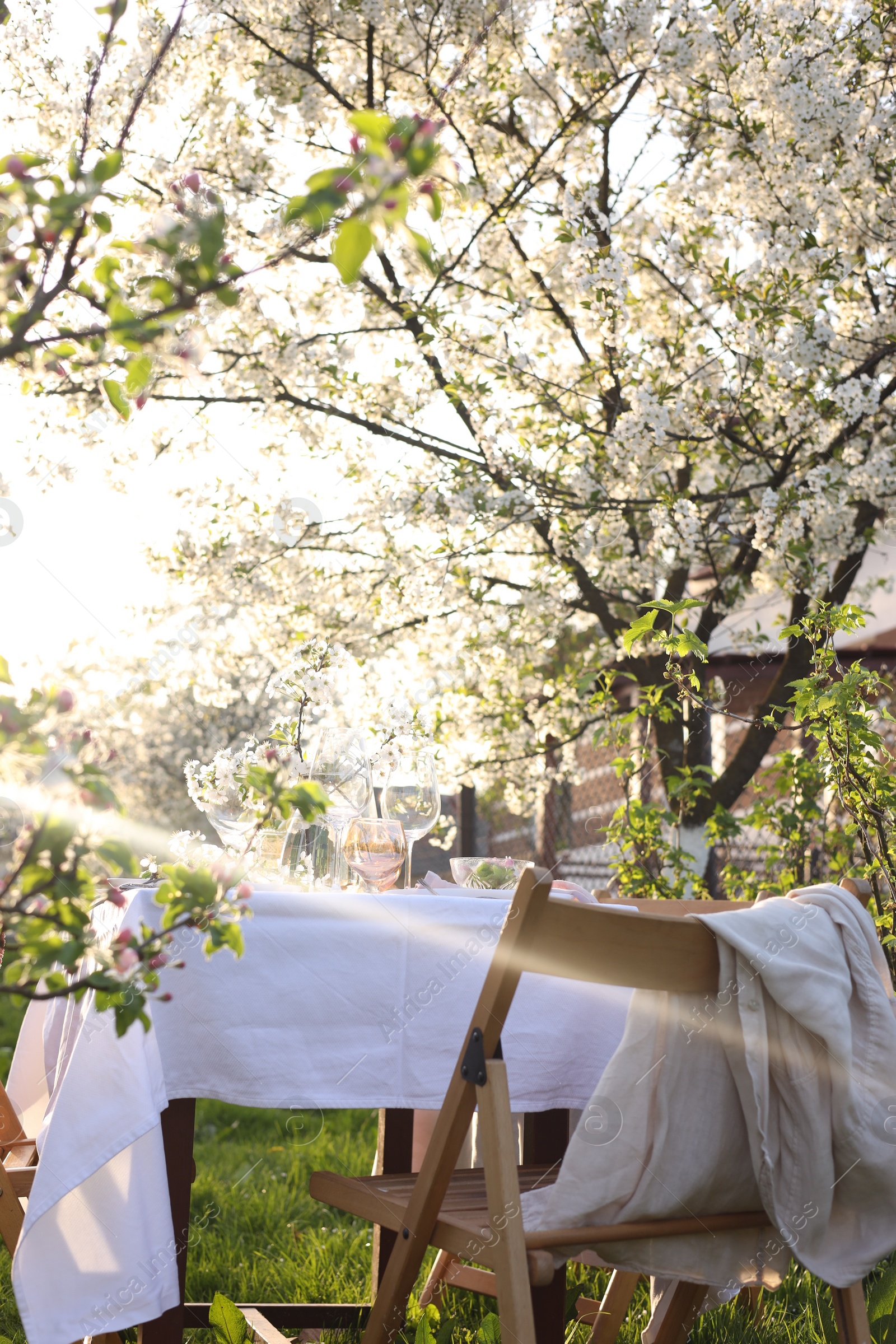 Photo of Stylish table setting with beautiful spring flowers in garden