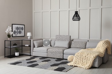 Photo of Living room interior with comfortable sofa near molding wall