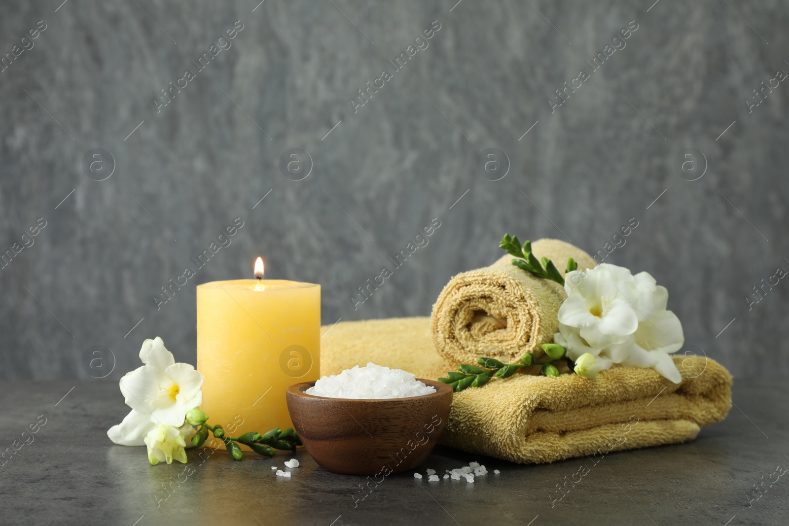 Photo of Composition with different spa products and burning candle on grey table