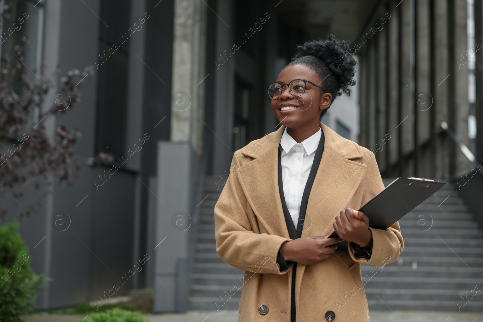 Photo of Happy woman with clipboard outdoors, space for text. Lawyer, businesswoman, accountant or manager