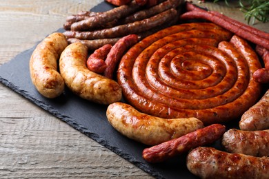 Photo of Different delicious sausages on wooden table. Assortment of beer snacks