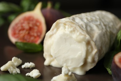 Photo of Delicious fresh goat cheese with figs and basil on plate, closeup