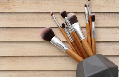 Photo of Makeup brushes on wooden background