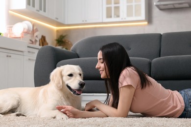 Photo of Happy woman with cute Labrador Retriever dog on floor at home. Adorable pet