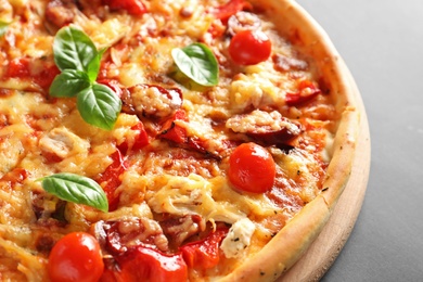 Delicious pizza with tomatoes and sausages on table, closeup