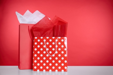 Photo of Shopping bags with paper on red background