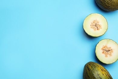 Photo of Ripe tasty melons on blue background, flat lay. Space for text