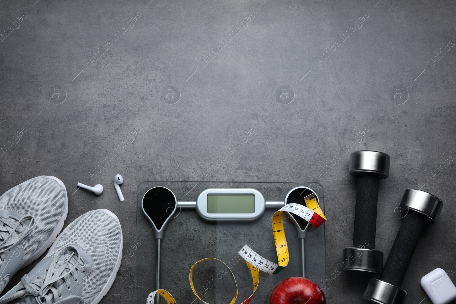 Photo of Flat lay composition with electronic scales and measuring tape on grey background, space for text