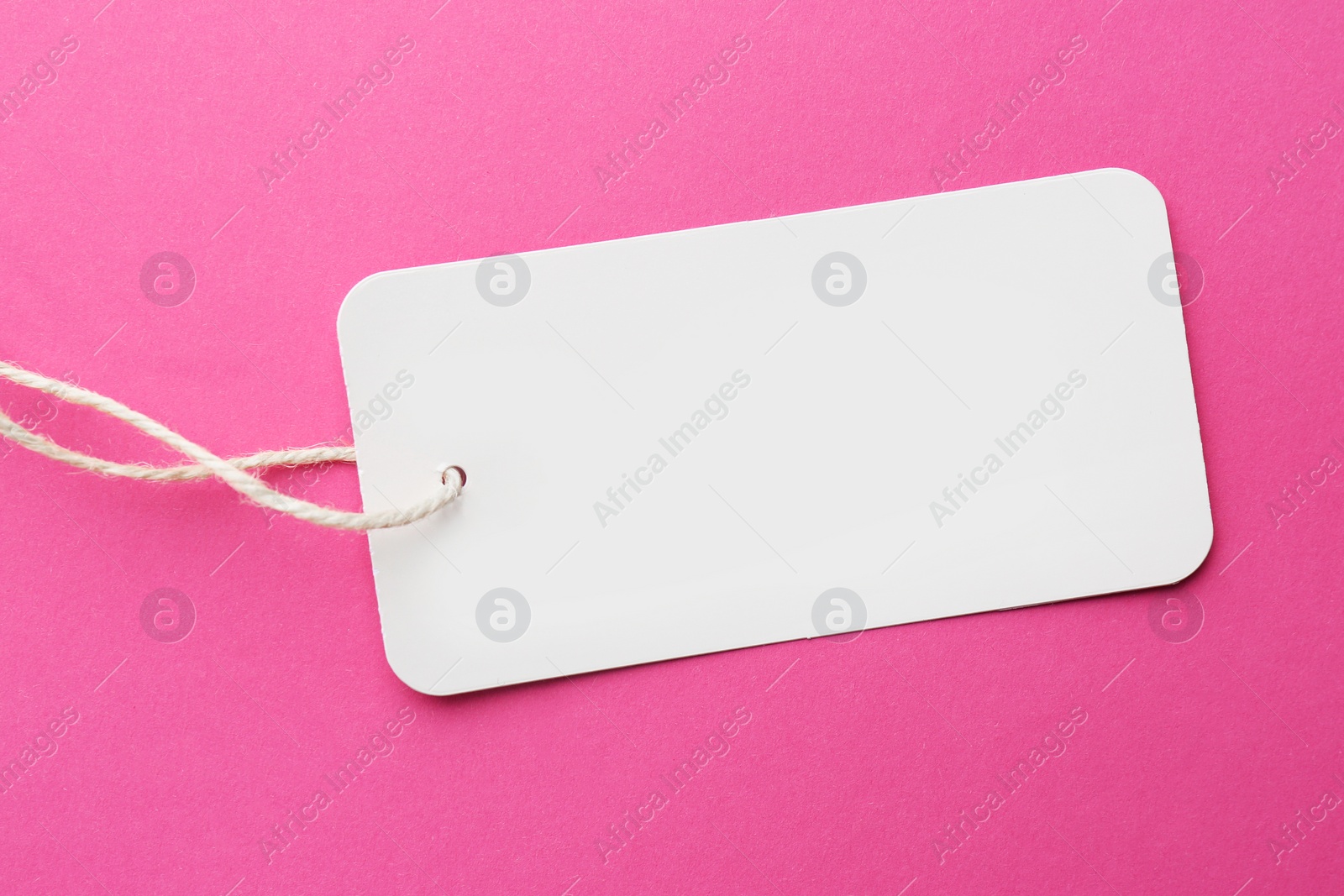 Photo of Tag with space for text on pink background, top view