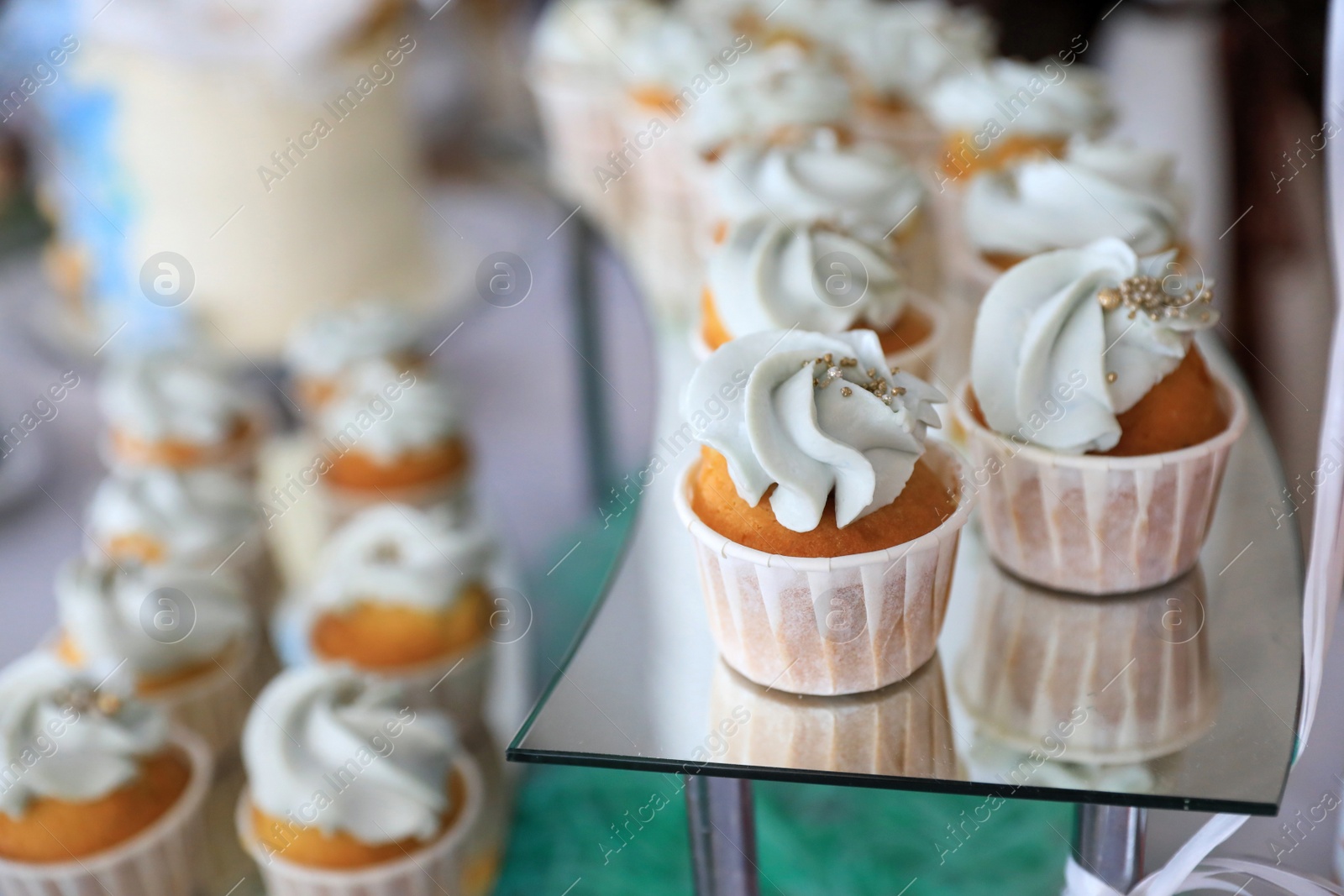 Photo of Delicious cupcakes with cream on dessert stand, closeup