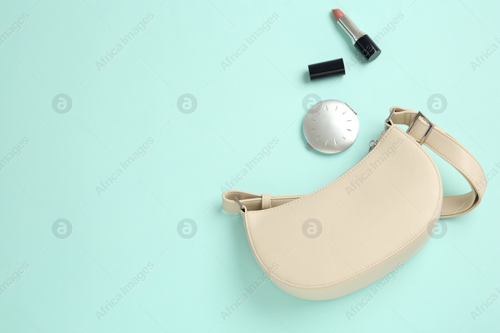 Photo of Flat lay composition with stylish baguette handbag on turquoise background. Space for text