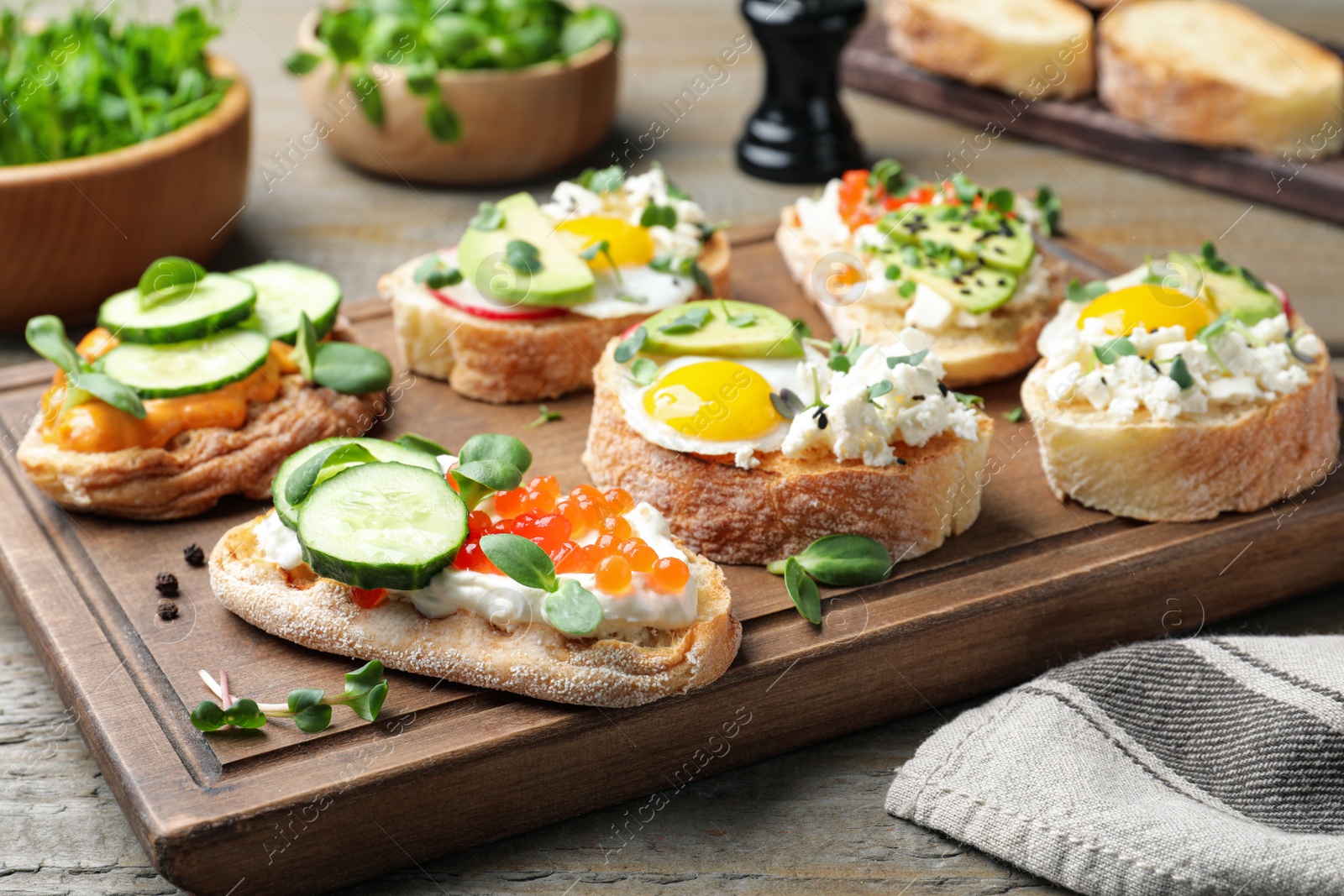 Photo of Different delicious sandwiches with microgreens on wooden table