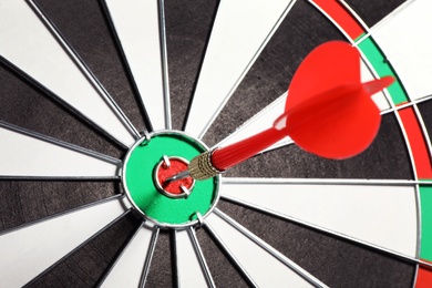 Photo of Dart board with red arrow hitting target, closeup