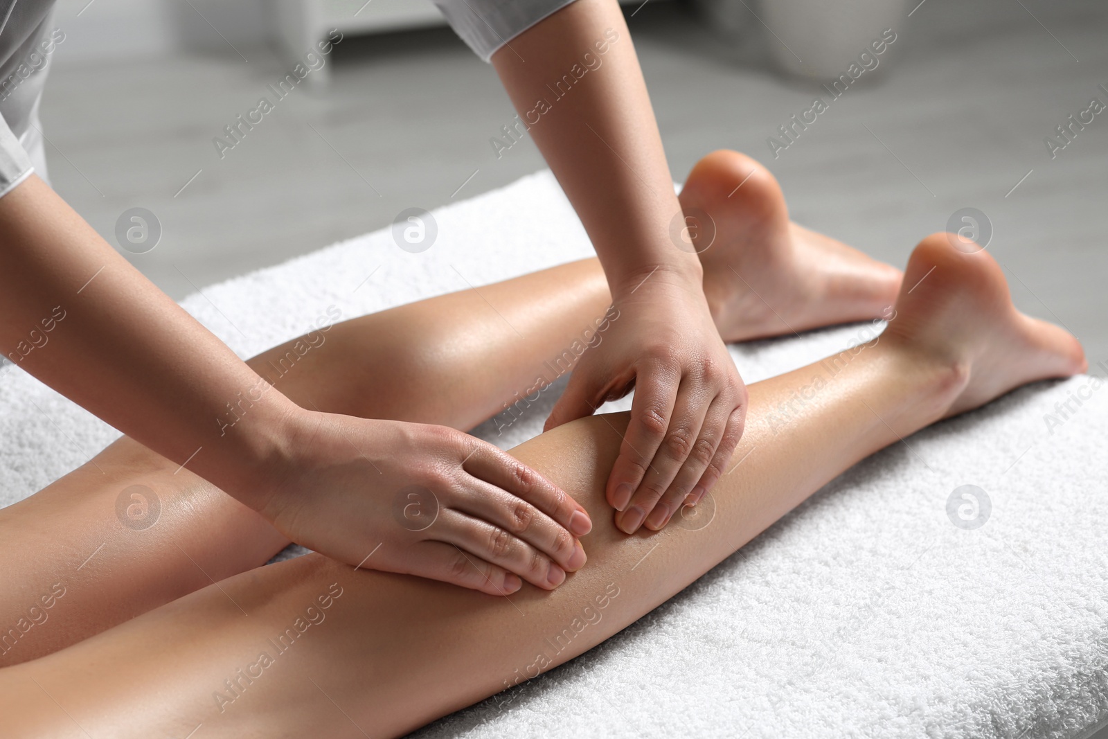 Photo of Woman receiving leg massage in spa salon, closeup