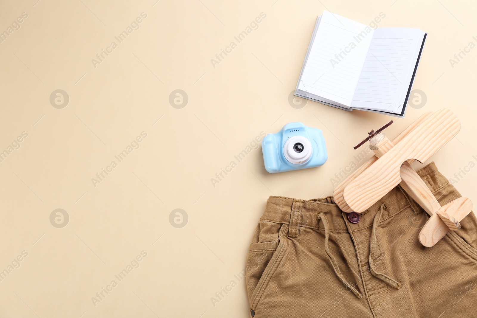 Photo of Flat lay composition with little photographer's toy camera on beige background. Space for text