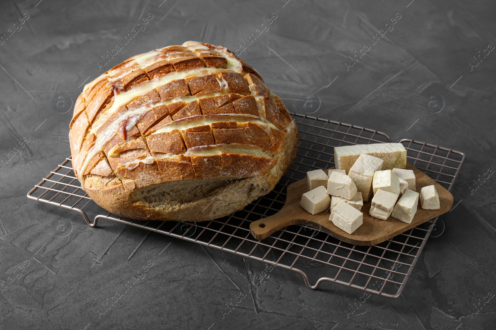 Photo of Freshly baked bread with tofu cheese on black table