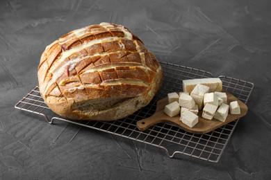 Photo of Freshly baked bread with tofu cheese on black table