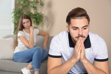 Photo of Young couple with relationship problems in living room