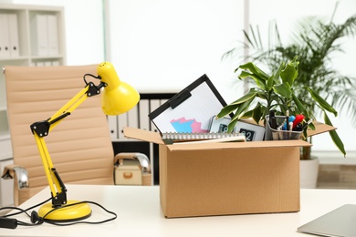 Cardboard box full of stuff on table in office