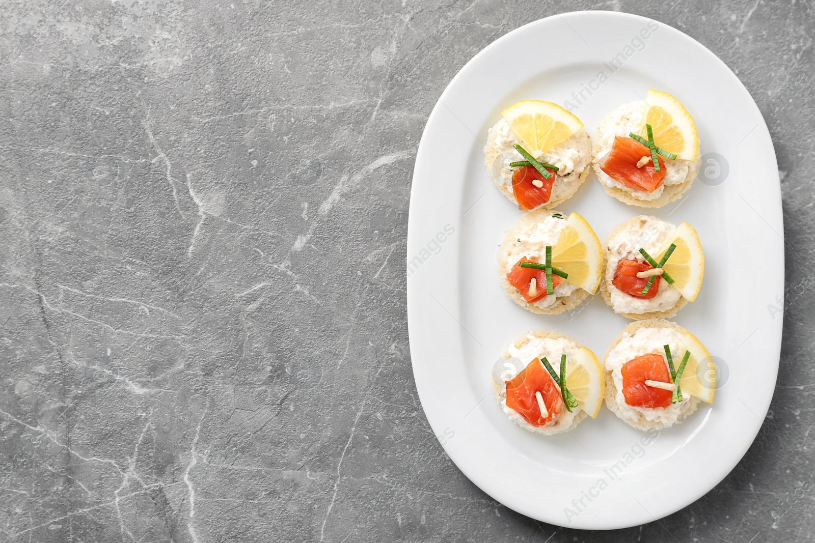 Photo of Canapes with fresh sliced salmon fillet on table, top view