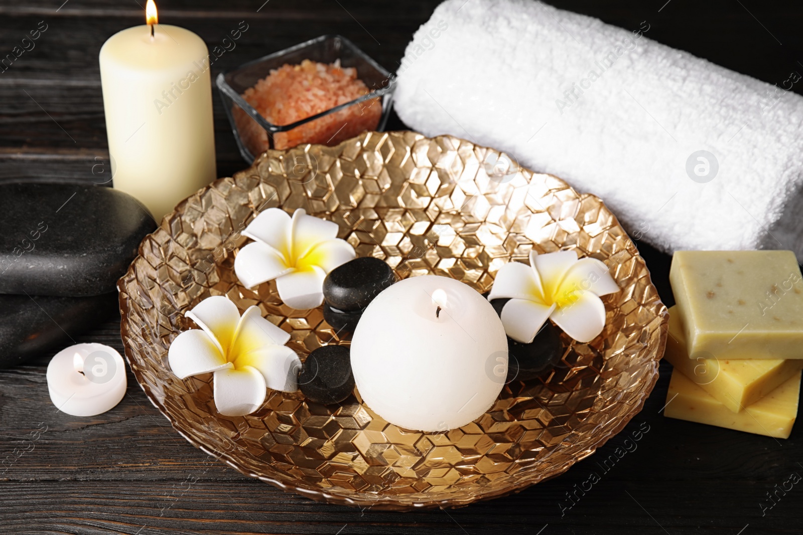 Photo of Beautiful spa composition with candles and flowers on wooden background