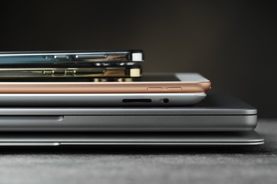 Photo of Stack of electronic devices on grey table, closeup