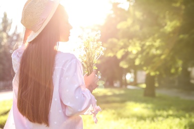 Photo of Young woman with beautiful bouquet outdoors on sunny day, space for text
