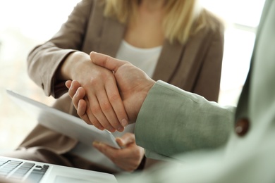 Photo of Business partners shaking hands after meeting, closeup