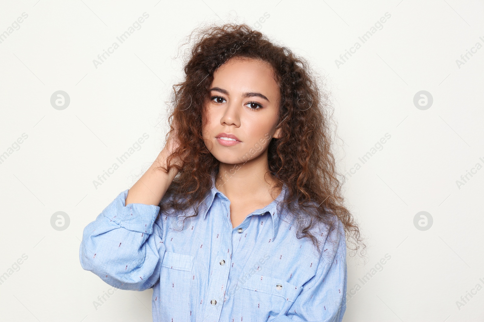 Photo of Young African-American woman with beautiful face on light background