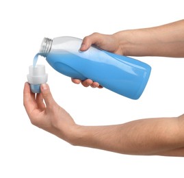 Photo of Man pouring fabric softener from bottle into cap for washing clothes on white background, closeup