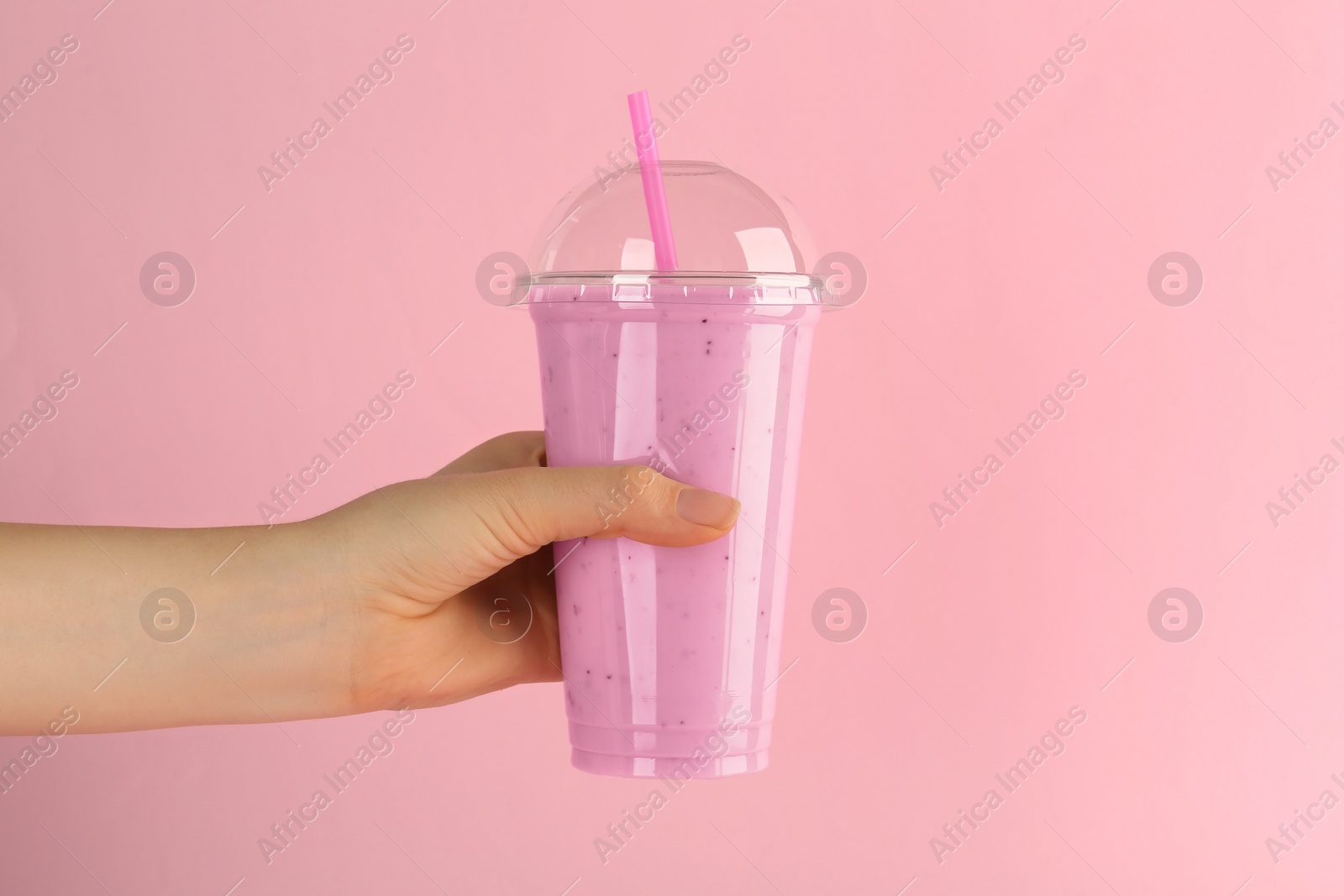 Photo of Woman with plastic cup of tasty smoothie on pink background, closeup