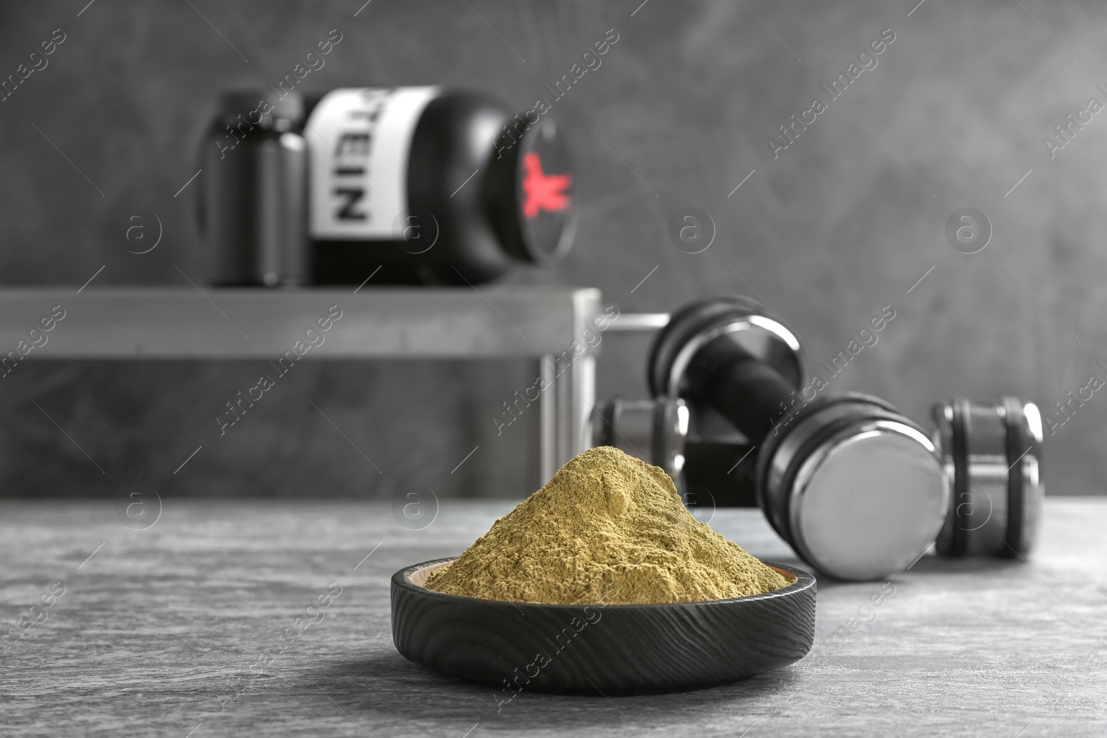Photo of Hemp protein powder in bowl and dumbbells on table. Space for text