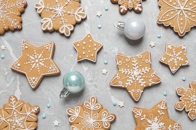 Photo of Tasty Christmas cookies and baubles on light grey marble table, flat lay