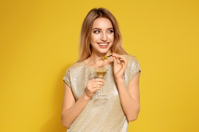 Photo of Beautiful young woman with glass of martini cocktail on color background