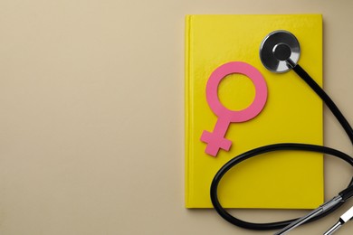 Photo of Female gender sign, stethoscope and notebook on beige background, top view with space for text. Women's health concept