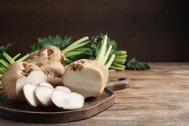 Photo of Cut sugar beets on wooden table. Space for text